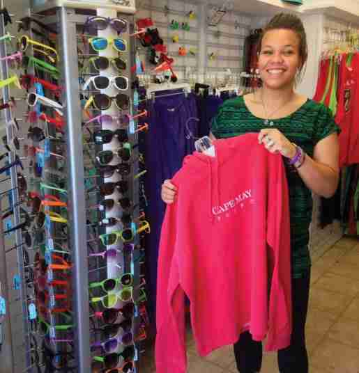 A woman photographed with a sweatshirt and sunglasses at Sunset Beach Gifts in Cape May Point, N.J. Shoppers can be reminded to buy sunglasses by placing them near the fitting room, where glasses can be tried on with apparel, or with a sunscreen display, according to the owner.
